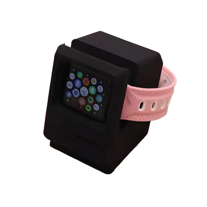 Apple Watch posée sur support rétro noir – écran d’accueil activé, bracelet rose pastel, sans fond