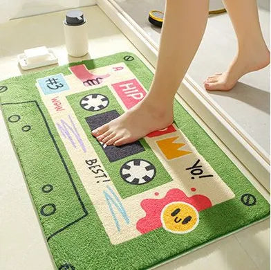 Tapis de bain cassette vert, posé près d’un lavabo, avec des pieds dessus, touche vintage et naturelle