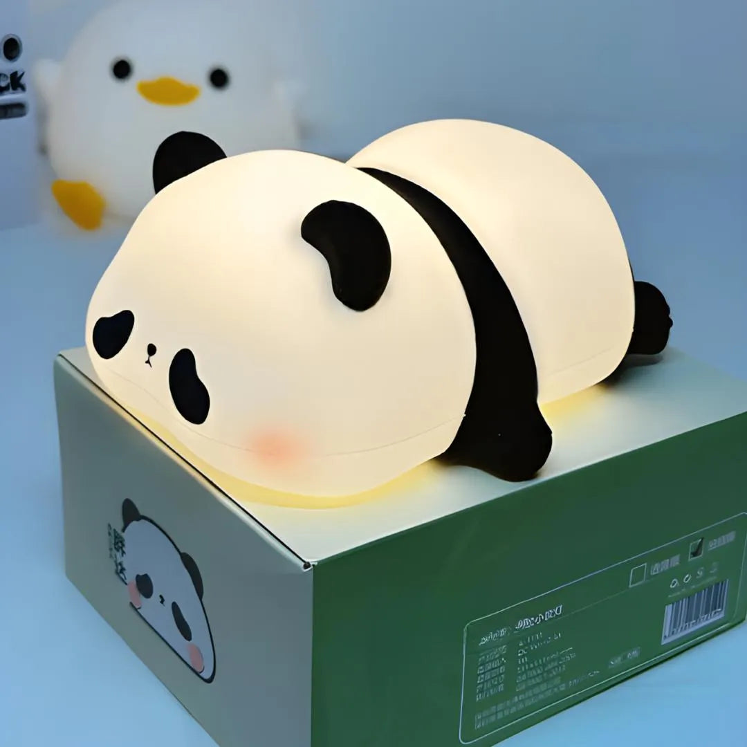 Veilleuse panda posée sur sa boîte d’origine, packaging vert illustré