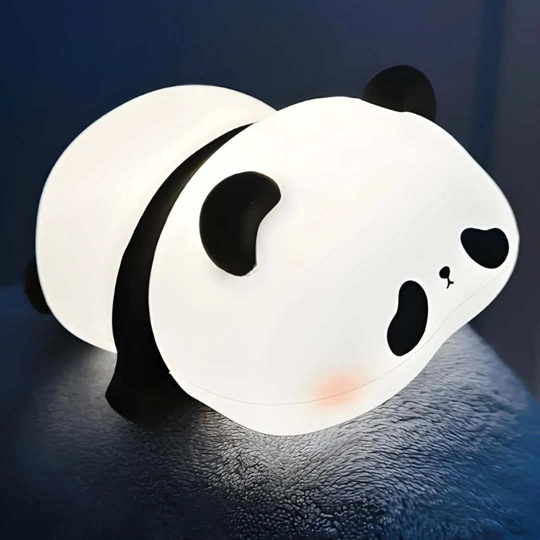 Veilleuse panda allumée sous une couverture, lumière douce idéale pour rassurer les enfants la nuit