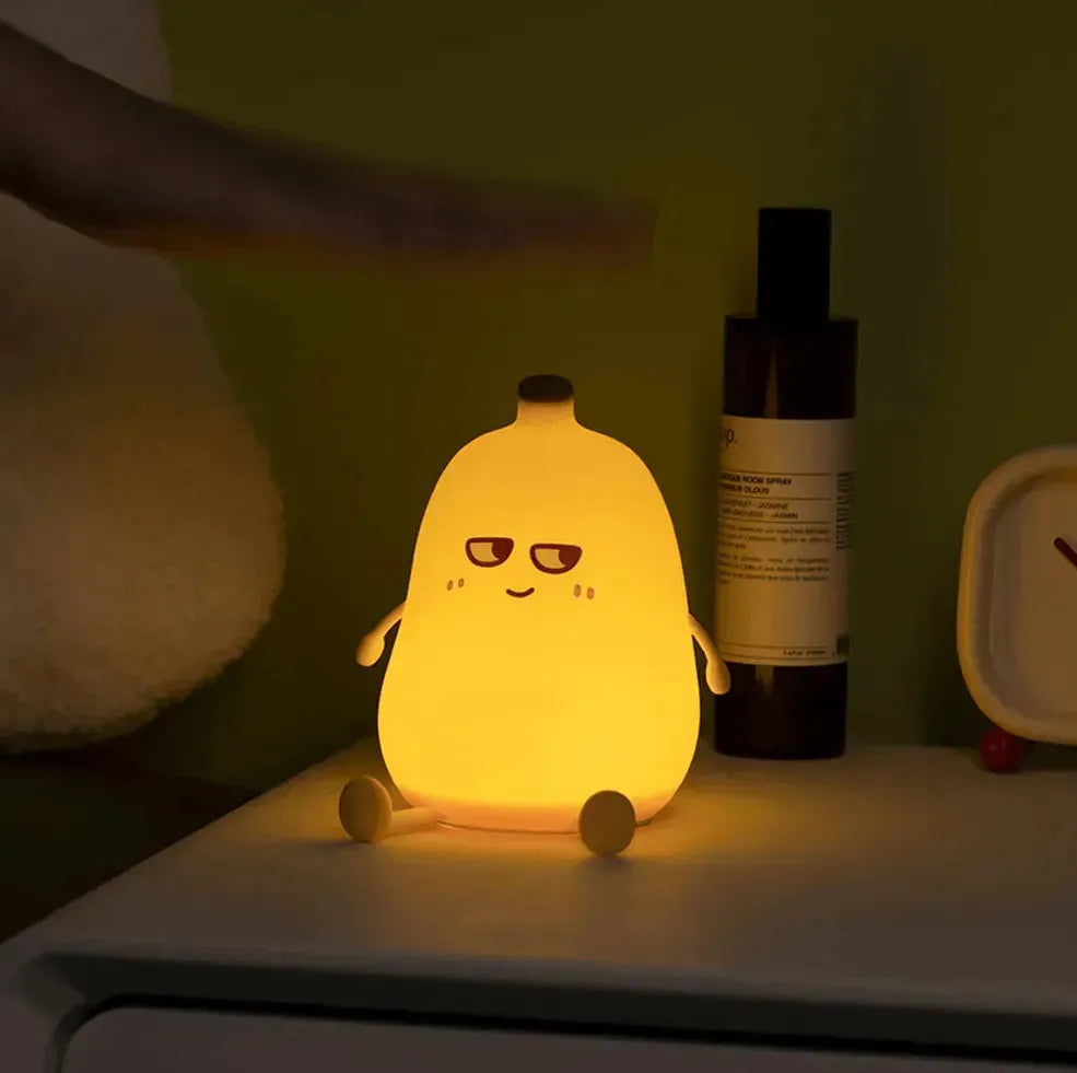 veilleuse banane illuminée posée sur table de chevet la nuit