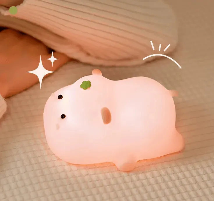 Veilleuse Hippopotame rose dans un lit de bébé