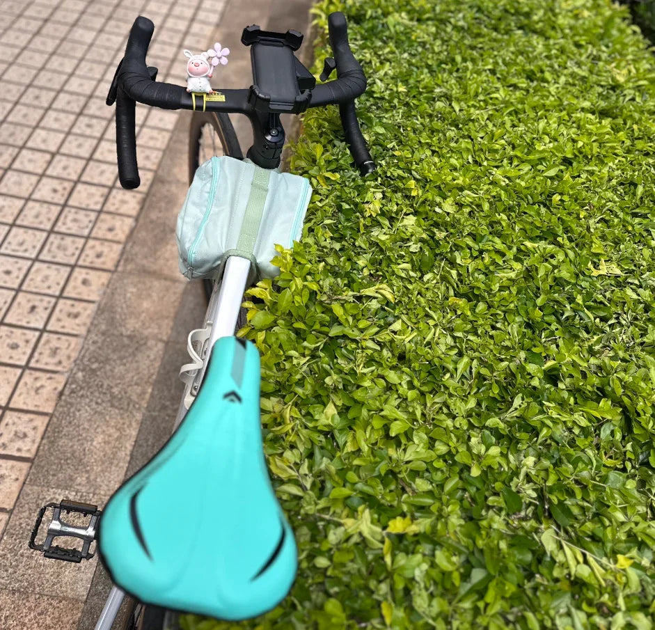 Vue arrière d’un vélo avec sac turquoise fixé au cadre – style épuré en situation réelle
