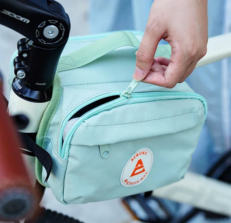Zoom sur une main accédant au sac de cadre vélo vert – ouverture facile et rapide